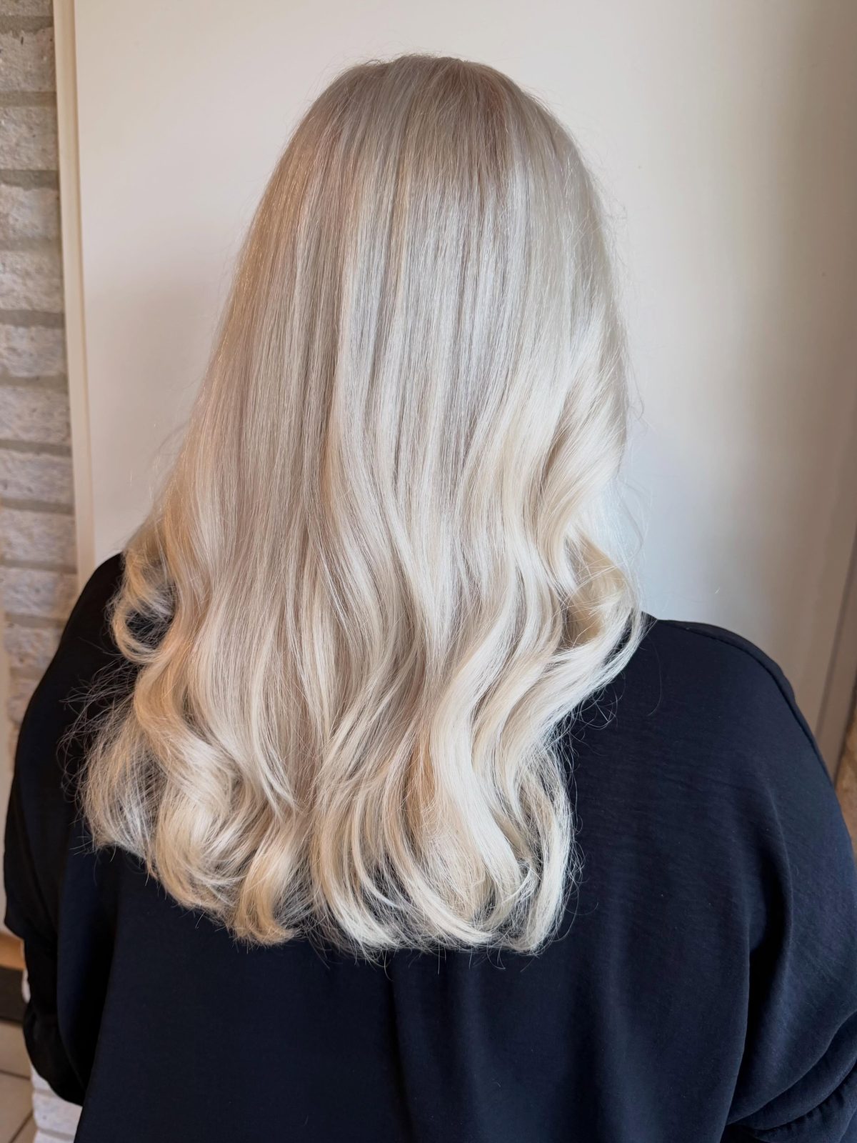 Lang, licht blond haar met zachte slagen, van achteren gezien