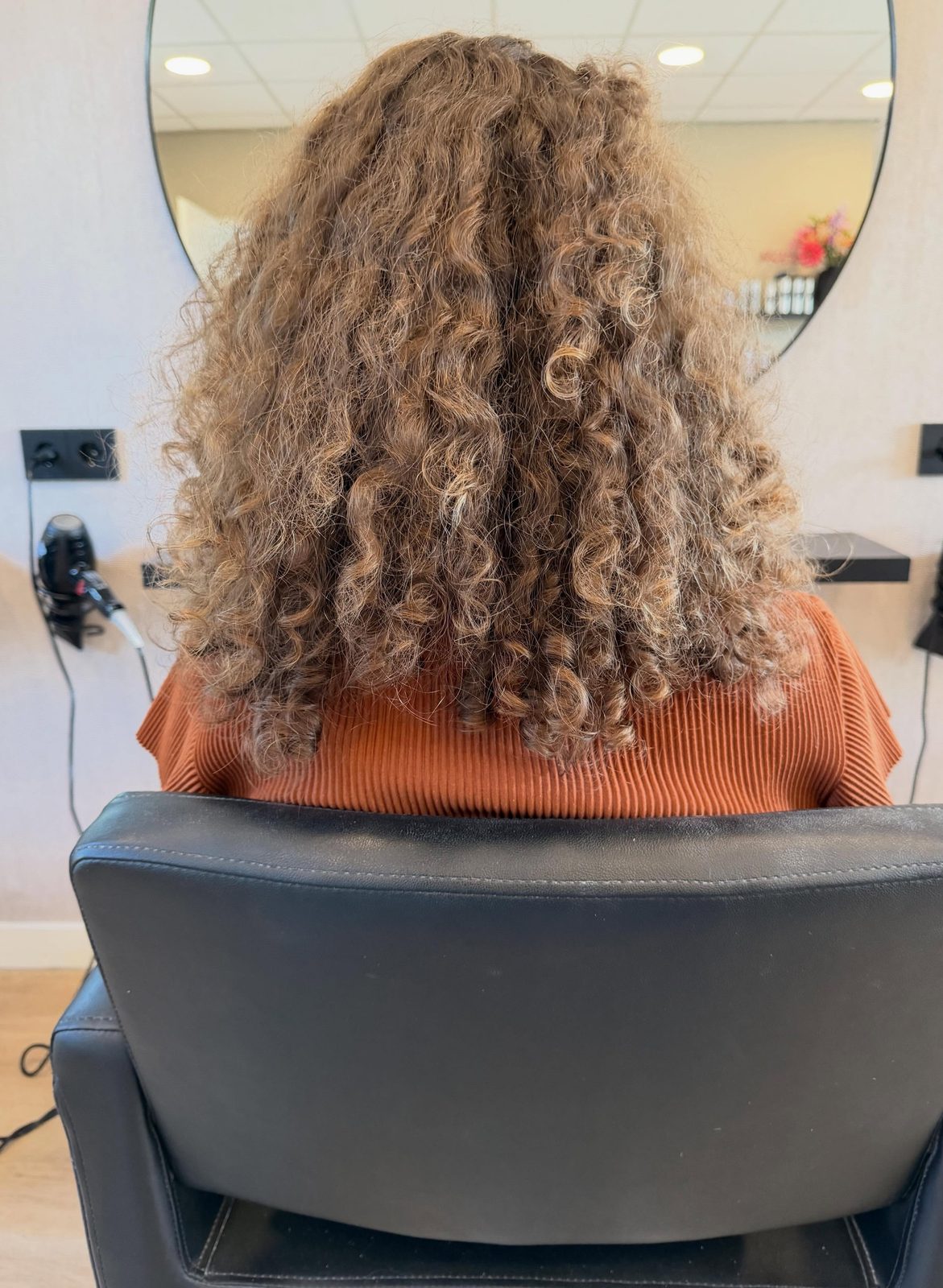 Lange losse krullen, van achteren gezien in de salon
